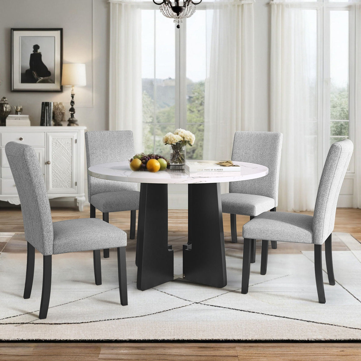 Round white marble-look dining table with four gray upholstered chairs and black base
