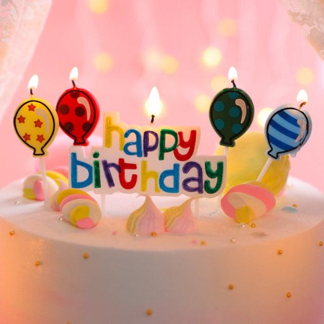 Happy Birthday cake candles with flaming wicks, balloon-shaped designs on sticks