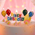 Happy Birthday cake candles with flaming wicks, balloon-shaped designs on sticks