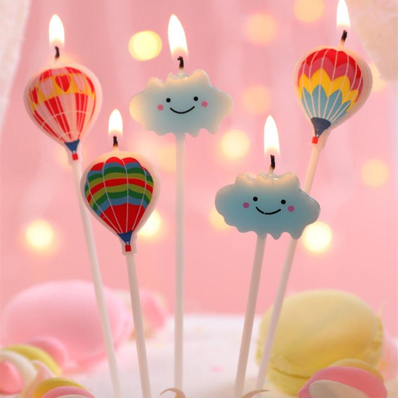 Set of smiling cloud and balloon birthday candles with flames for cake decoration