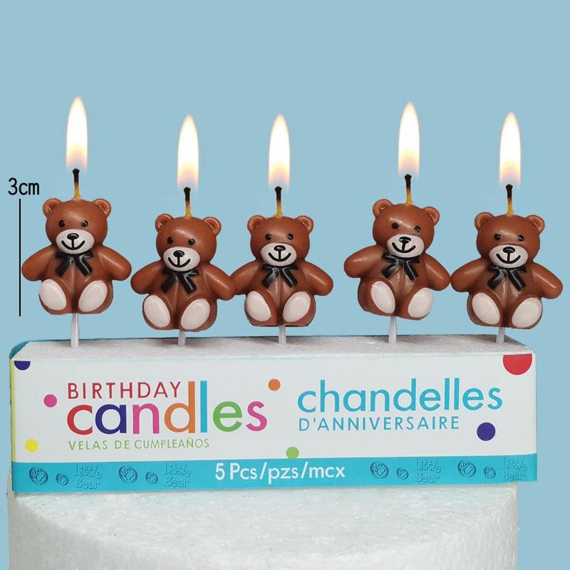 Teddy bear birthday candles: five brown bear figures with burning flames on cake