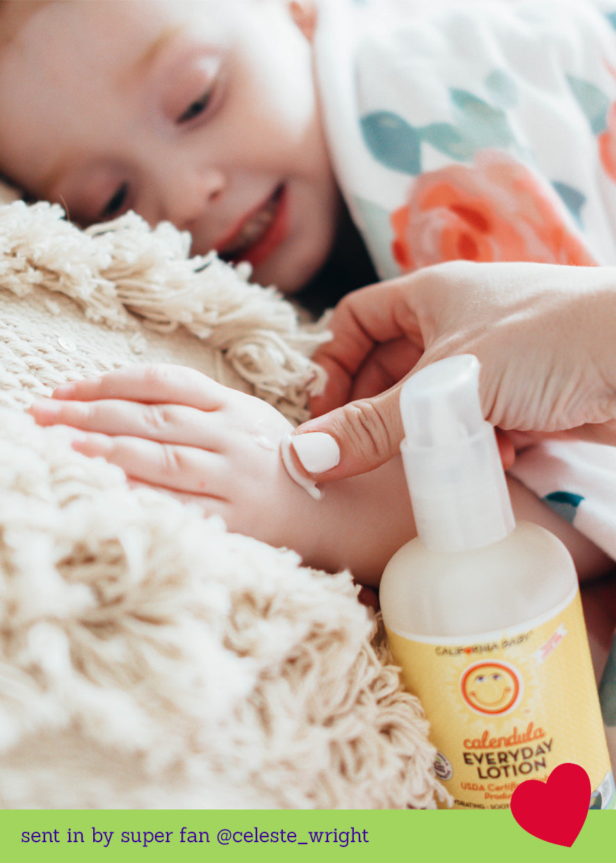 Calendula Everyday Lotion pump bottle with lotion being applied to a baby