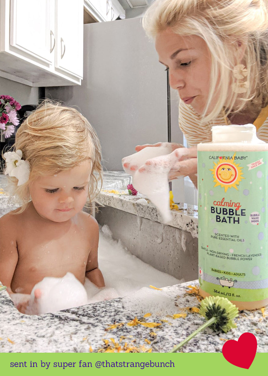 Bubble bath bottle beside bath foam during baby bath