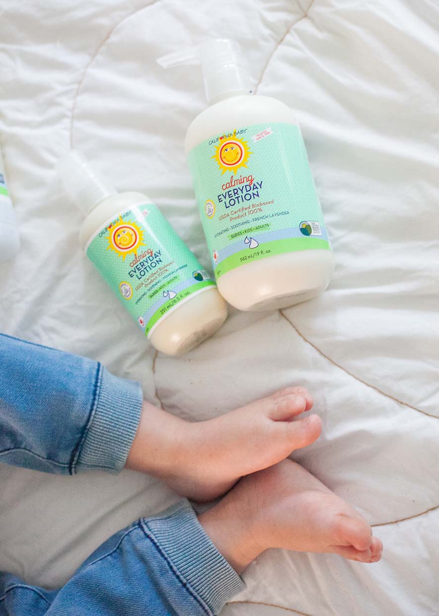Calming Everyday Lotion bottles held in hands over bed