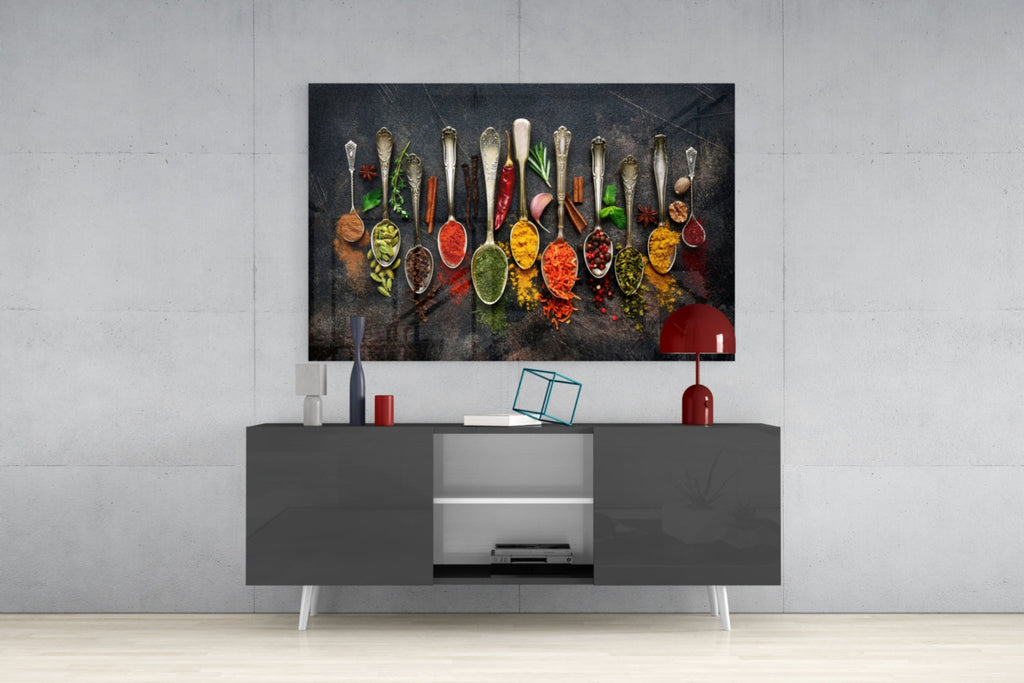 Glass wall art of colorful spice spoons arranged in a row on a dark backdrop