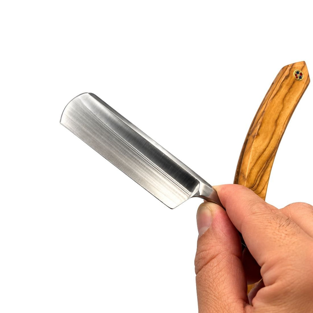 Wood-handled straight razor with open stainless blade in hand