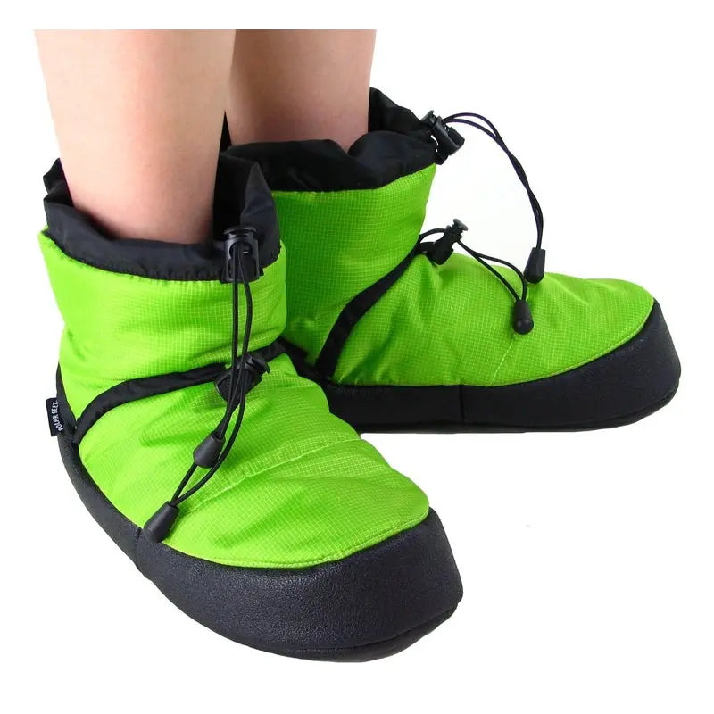 Lime green camp booties on feet with black drawstring lace-up closures