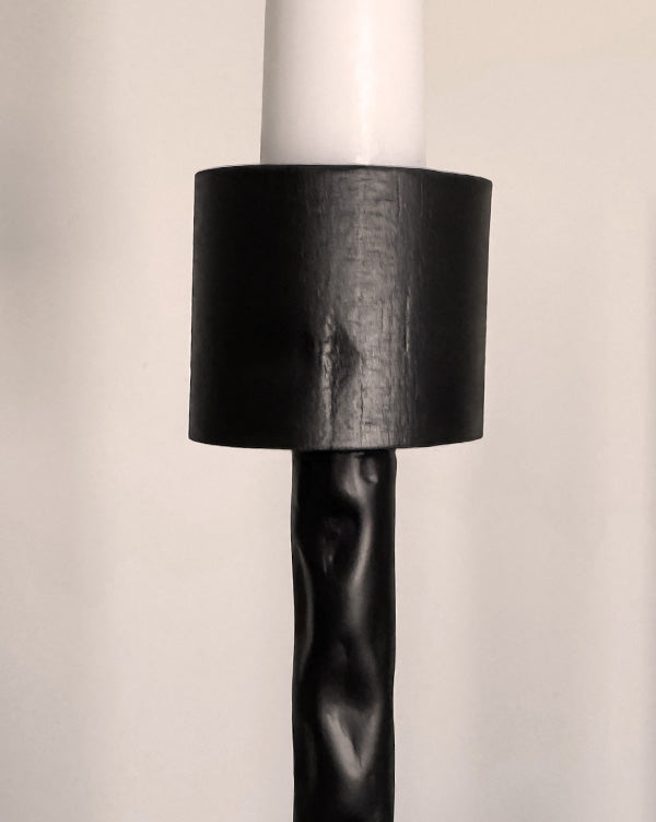 Black iron candelabra column with cylindrical candle shade holder, matte finish.