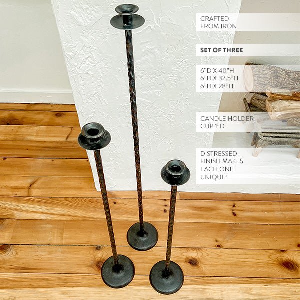 Tall cast iron floor candle holders, distressed black finish, three-piece set with round tops.