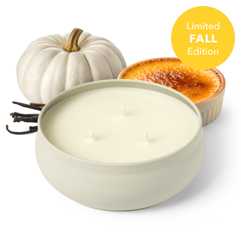 White round 3-wick candle in a tin with unlit wicks, with a white pumpkin nearby