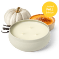 White round 3-wick candle in a tin with unlit wicks, with a white pumpkin nearby