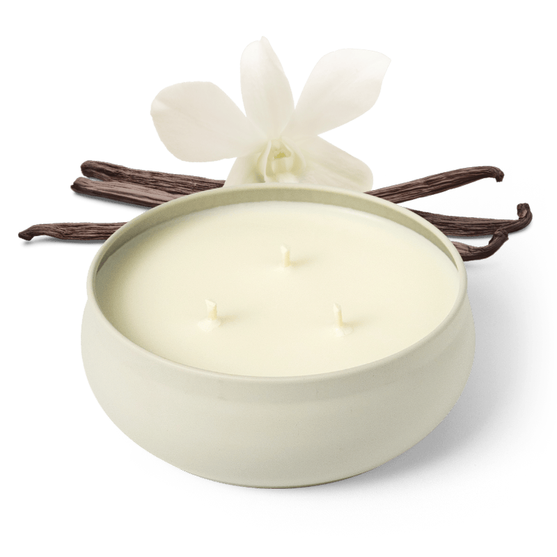 White 3-wick candle in round jar, three flames visible, with orchid flowers