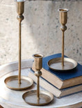 Set of three gold-tone plate candlestick holders with round bases