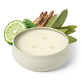 White round 3-wick candle with three flames, set with citrus slices and green leaves