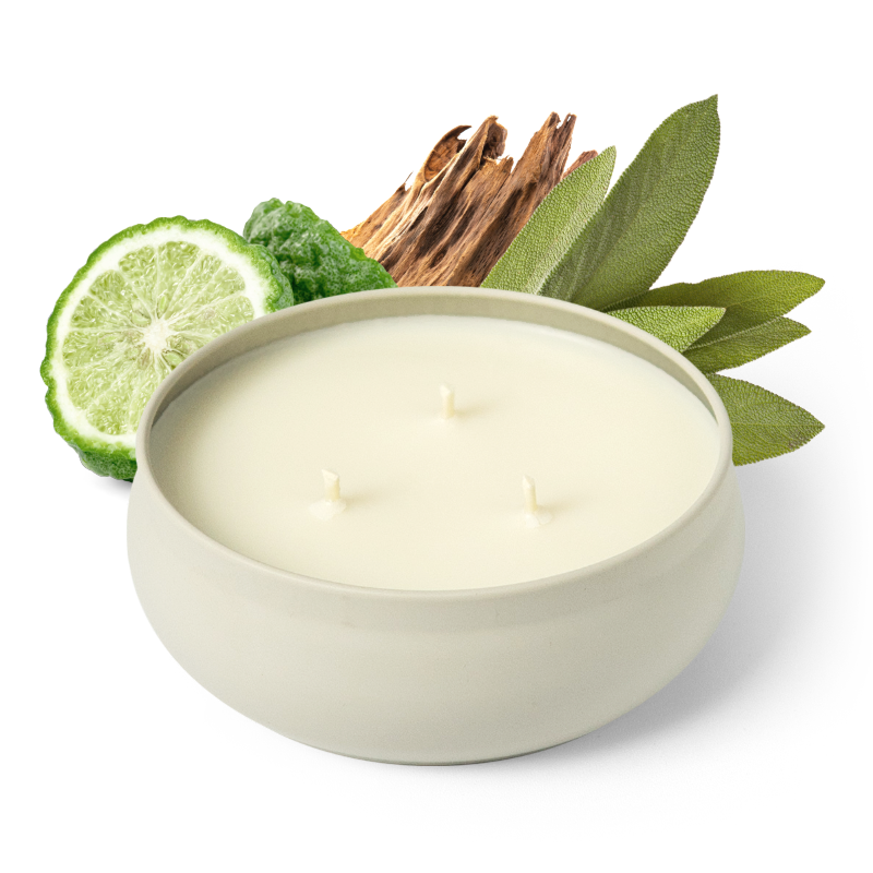 White round 3-wick candle with three flames, set with citrus slices and green leaves