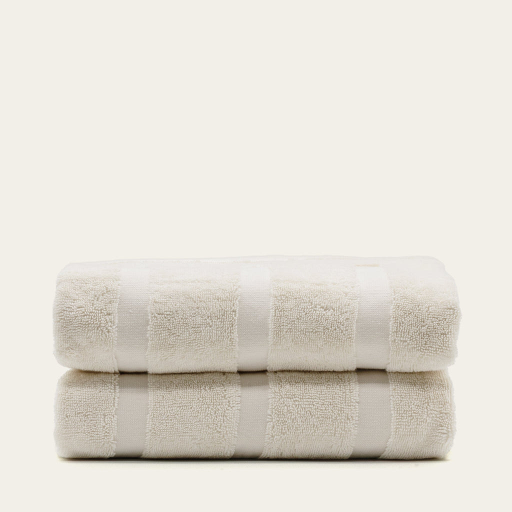Ecru cotton towels with terry loops and banded border