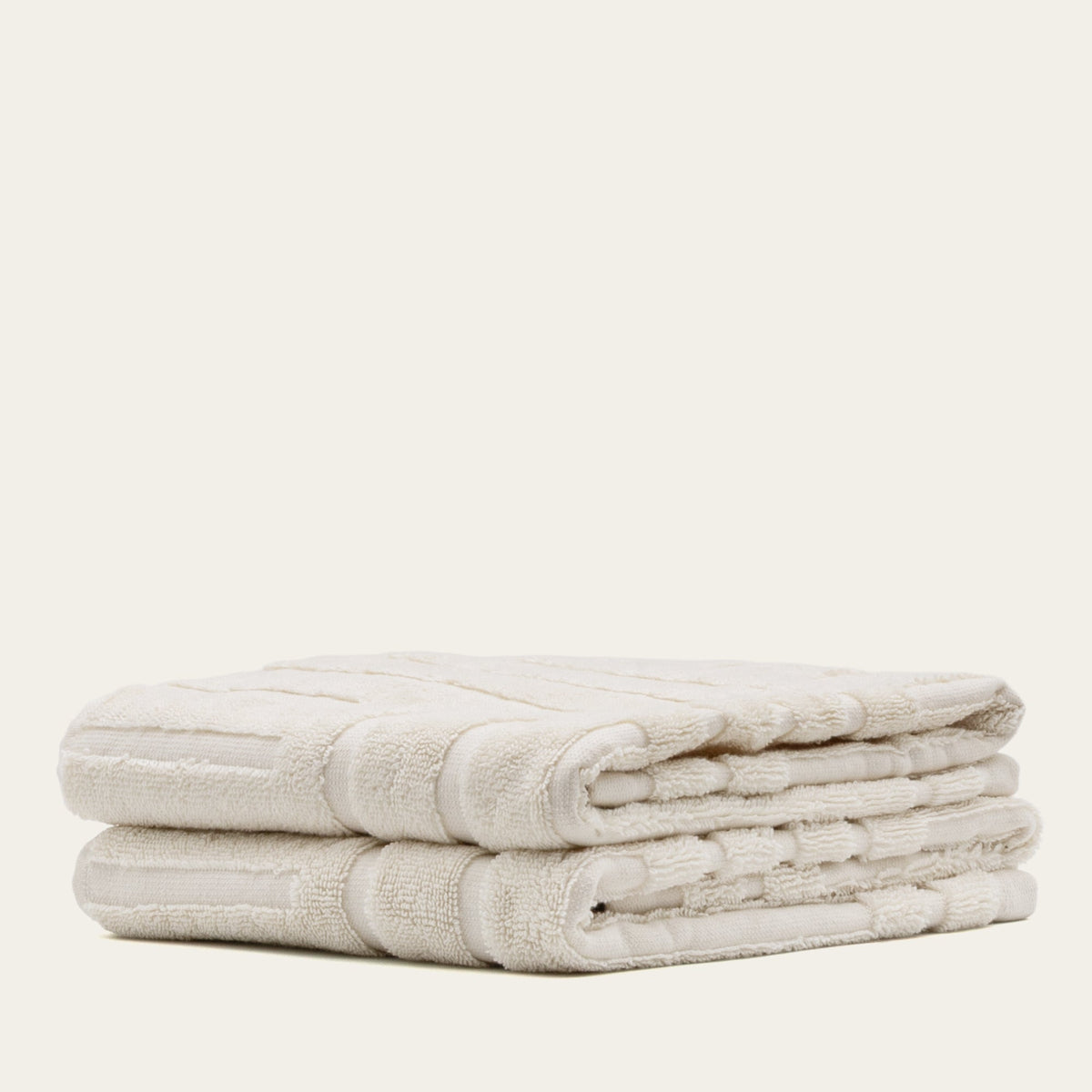 Cream cotton towel stack with banded wrap and textured terry loops