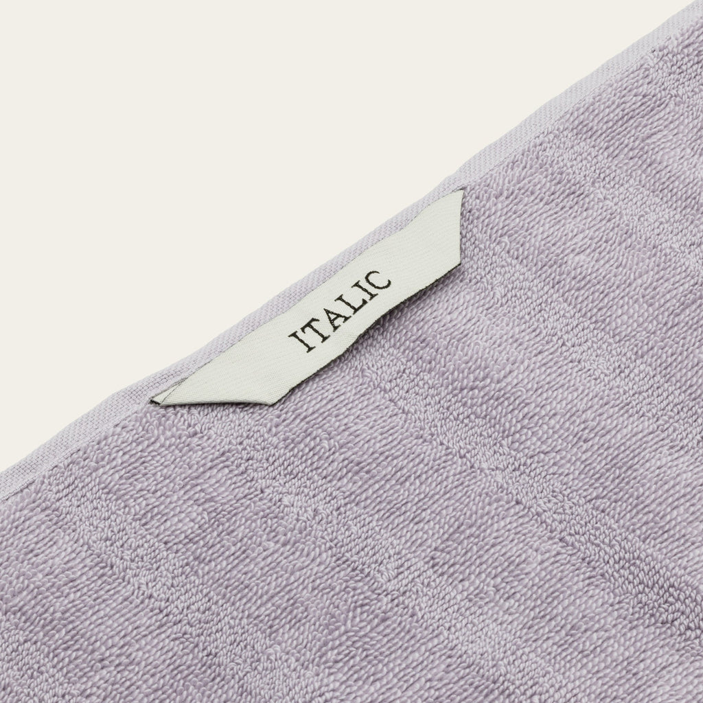 Lilac cotton towel corner with woven decorative band and label