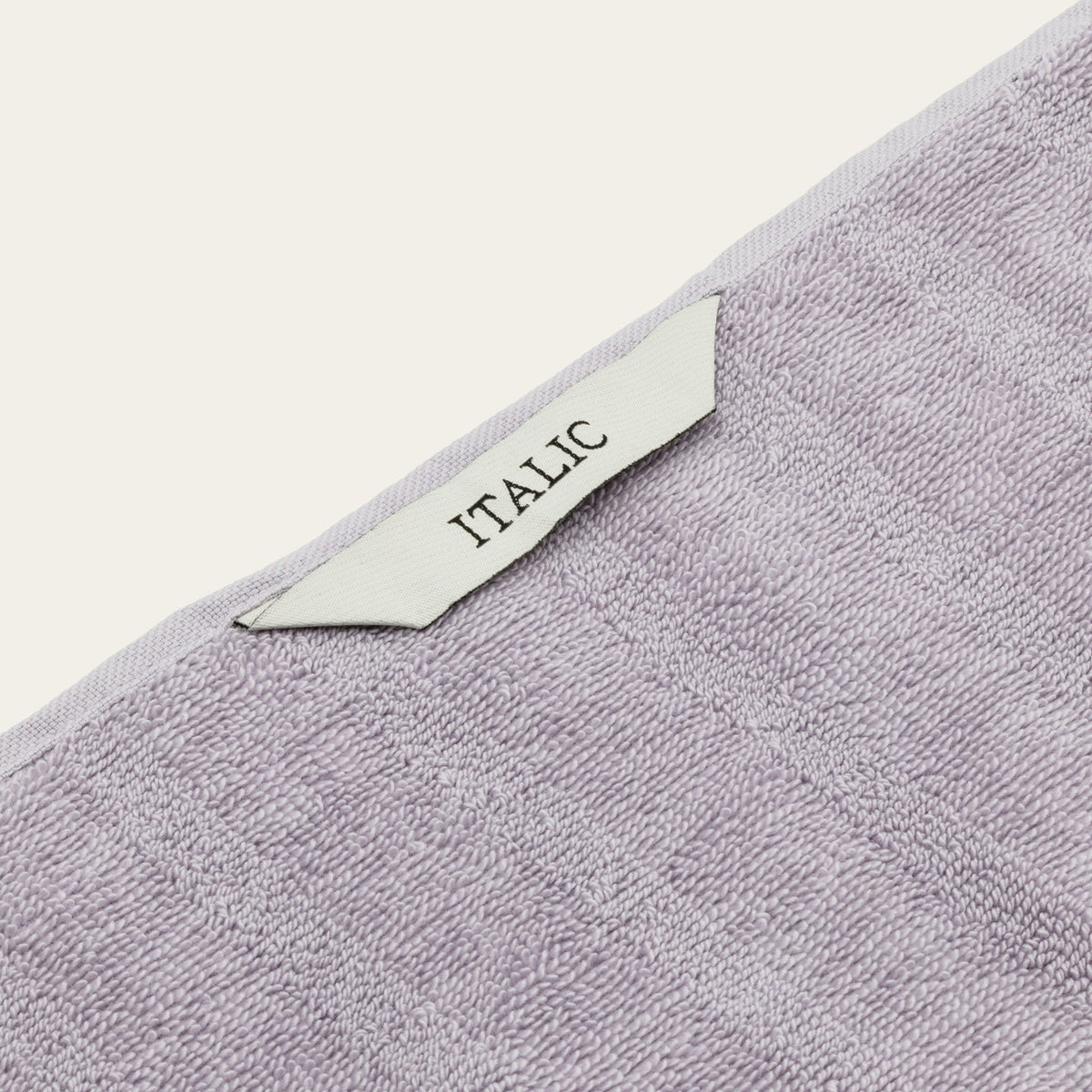 Lilac cotton towel with woven edge label reading ITALIC