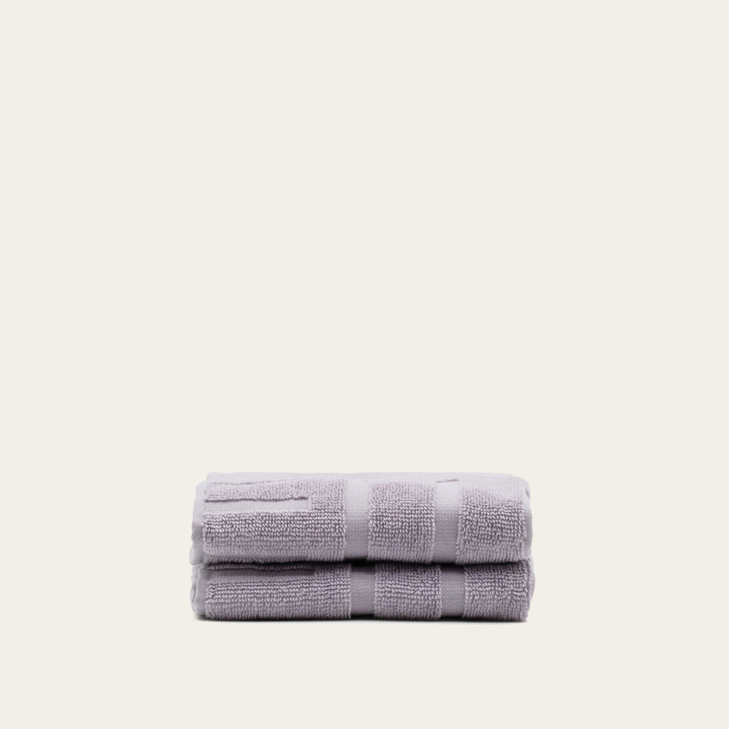 Lavender cotton towels, folded stack with terry texture and horizontal bands