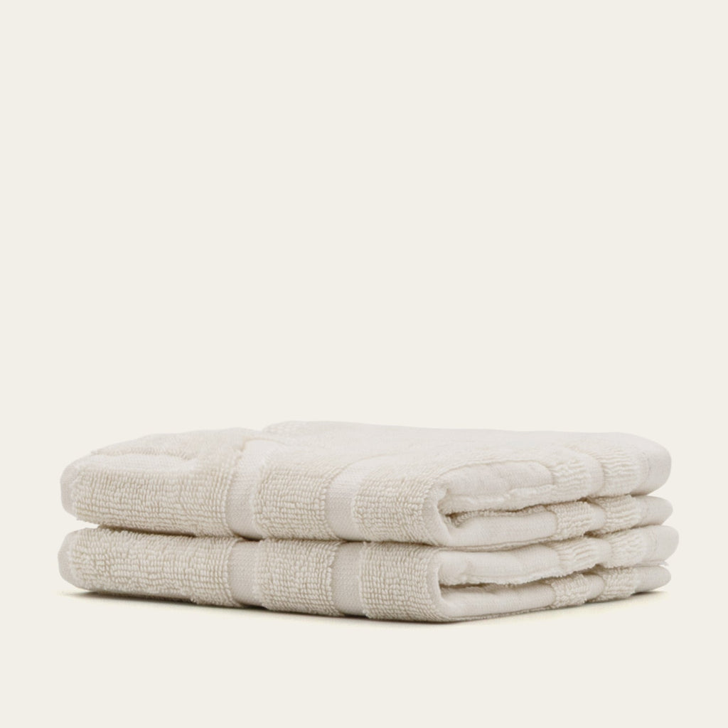Ecru cotton towel stack with textured weave and folded edges
