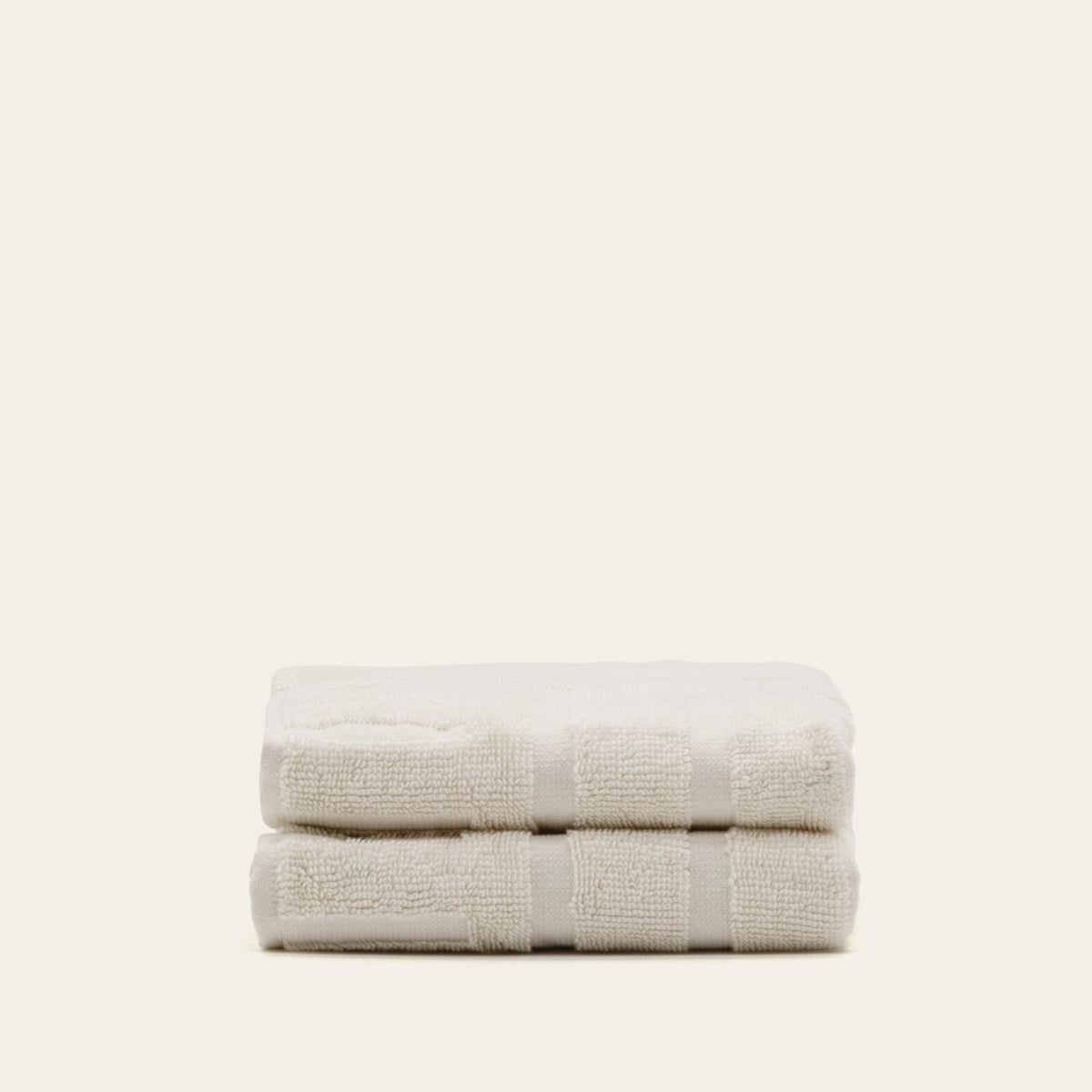 Ecru cotton hand towel folded with textured surface and banding
