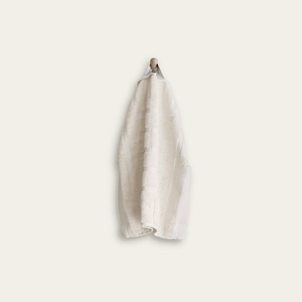 Single light beige cotton hand towel with folded top and hanging loop