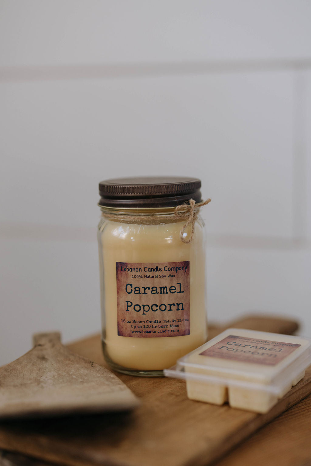 Caramel popcorn candle in glass jar with brown label and dark metal lid