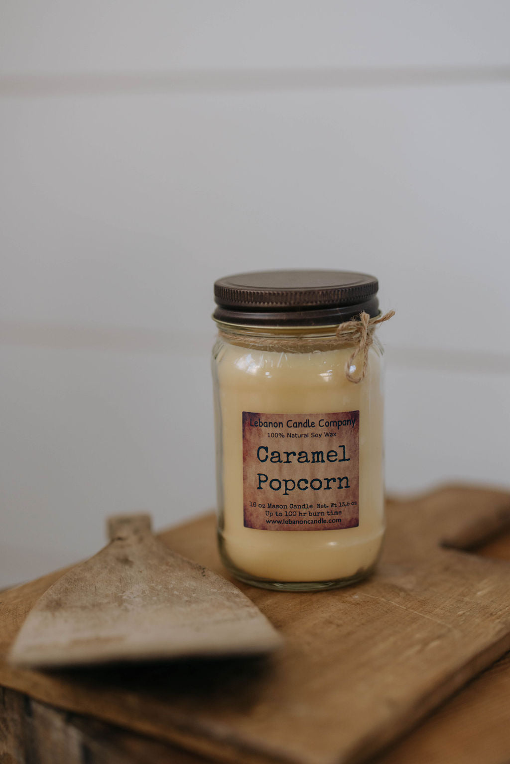 Caramel popcorn candle in glass jar with cream wax and dark metal lid