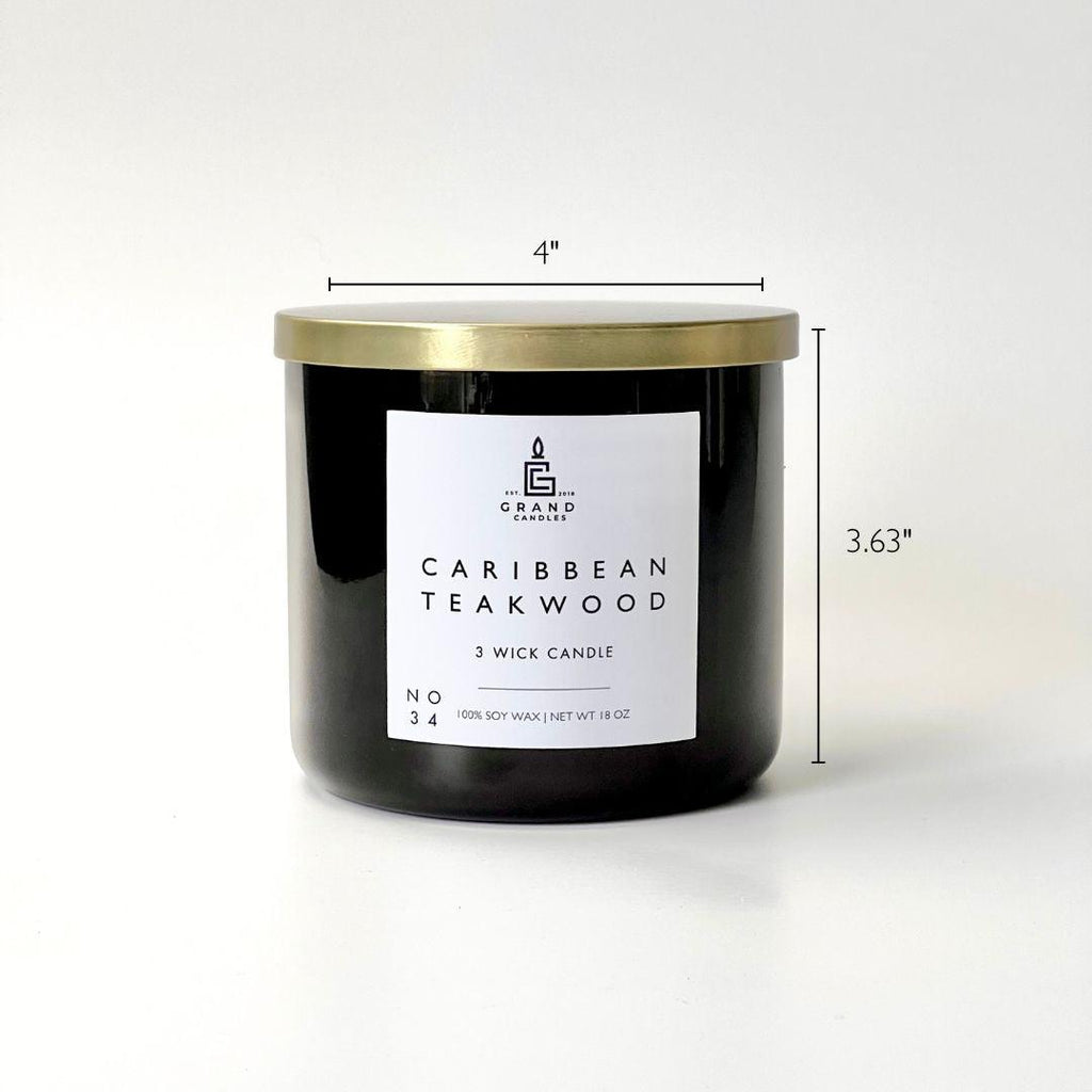 Caribbean teakwood soy candle black glass jar with white label and gold lid.