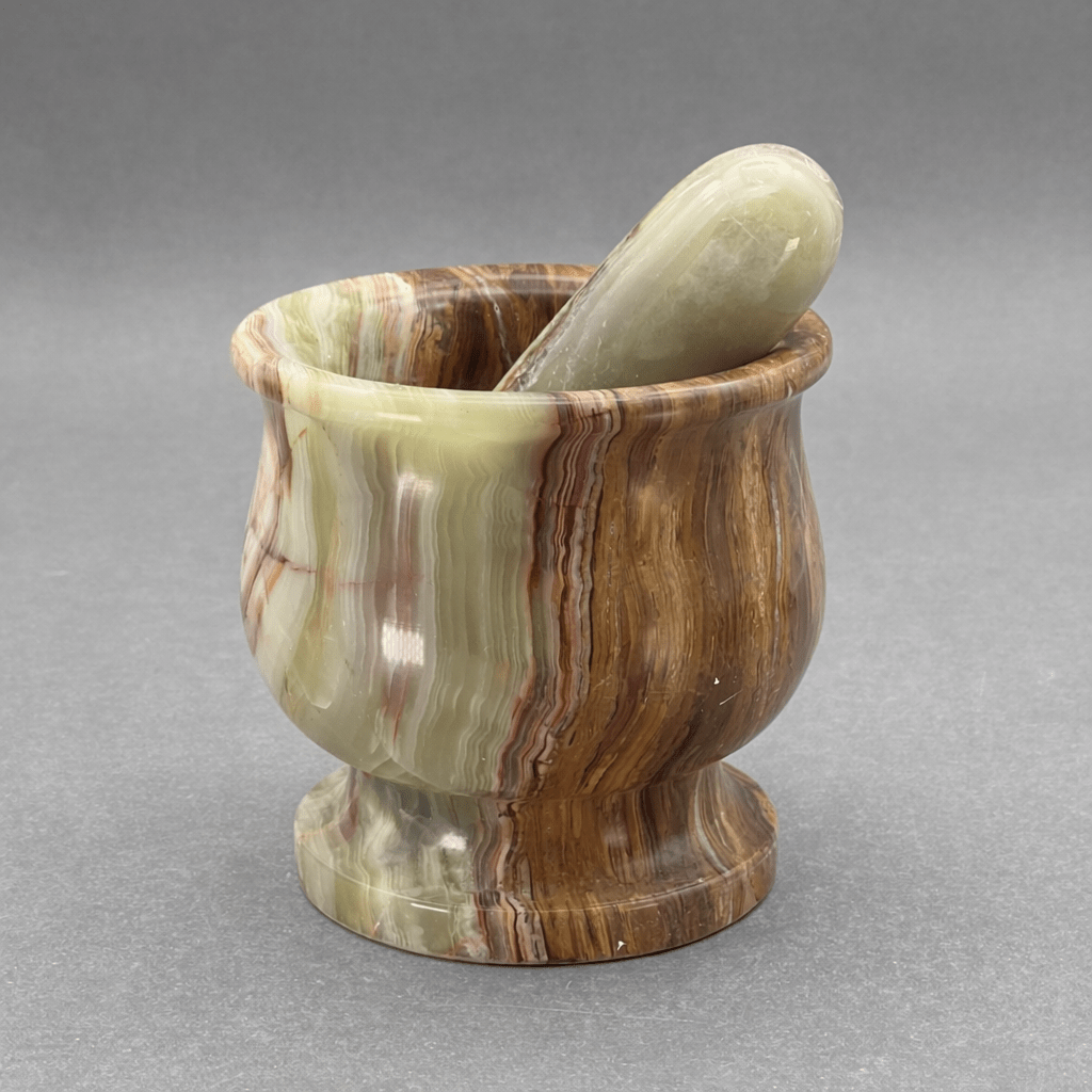 Carved onyx mortar and pestle set with pestle inside mortar, swirled brown and cream