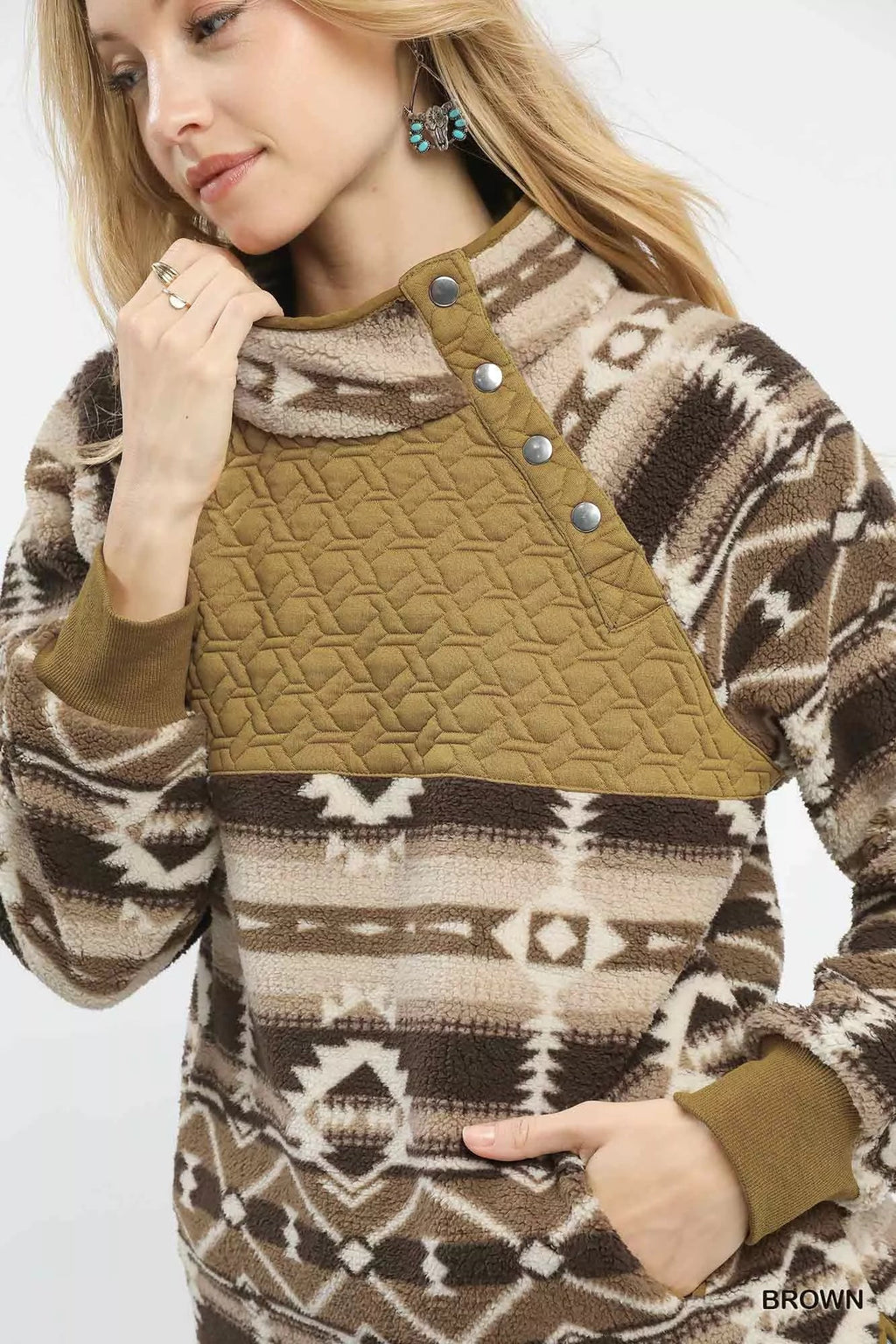 Close-up of brown Aztec sherpa pullover with snap buttons and quilted front panel