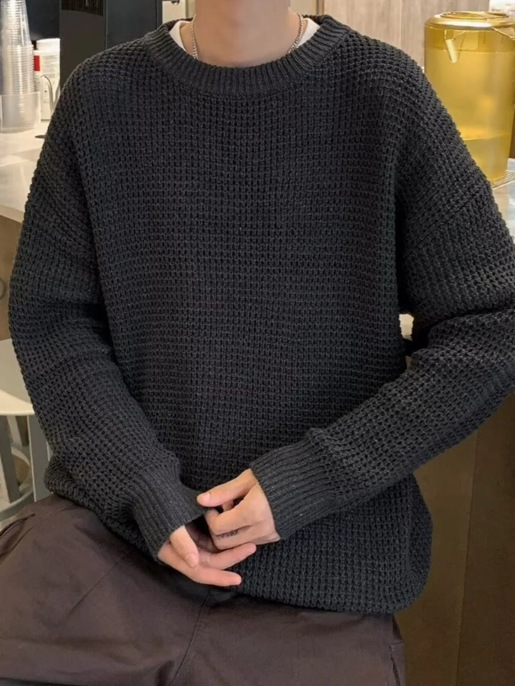Black waffle-knit crewneck sweater with ribbed cuffs and hem, long sleeves