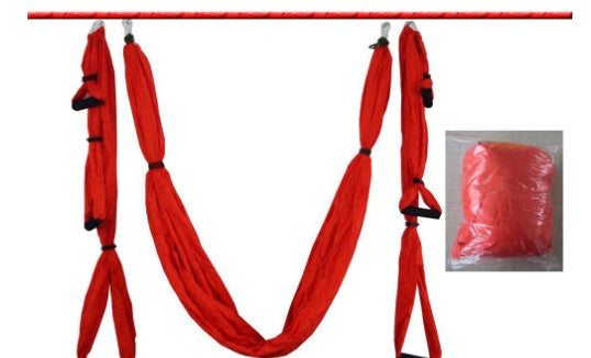 Red yoga swing hammock with hanging fabric loops and straps