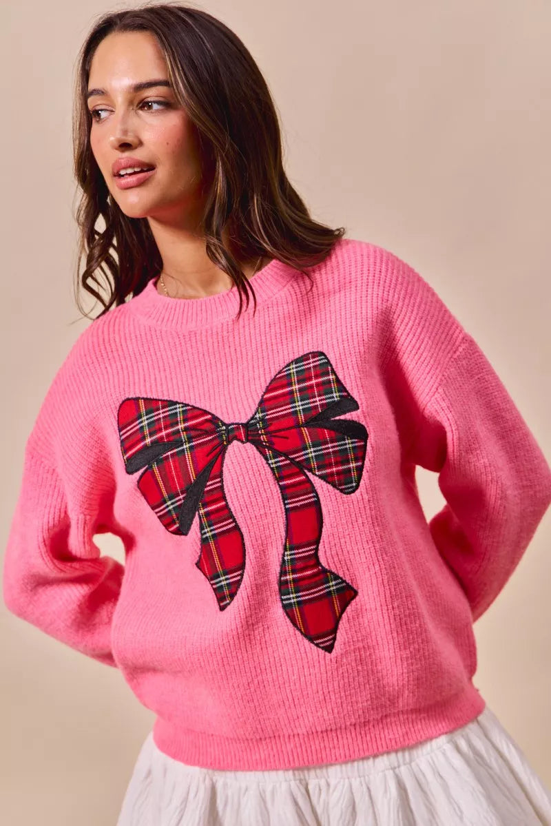 Pink knit sweater with large plaid bow ribbon applique on the front