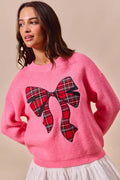 Pink knit sweater with large plaid bow ribbon applique on the front