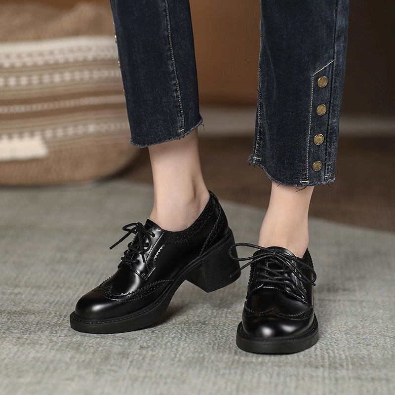 Black lace-up chunky heel shoes with round toe, glossy finish, on low block heels.