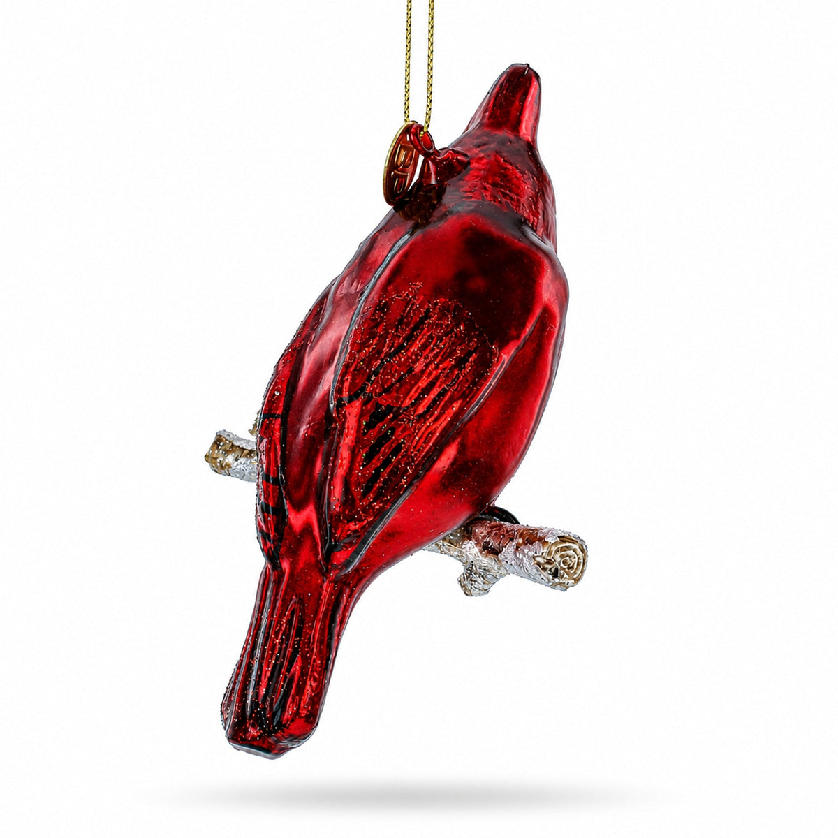 Red cardinal blown glass ornament back view on snowy branch with gold cord.