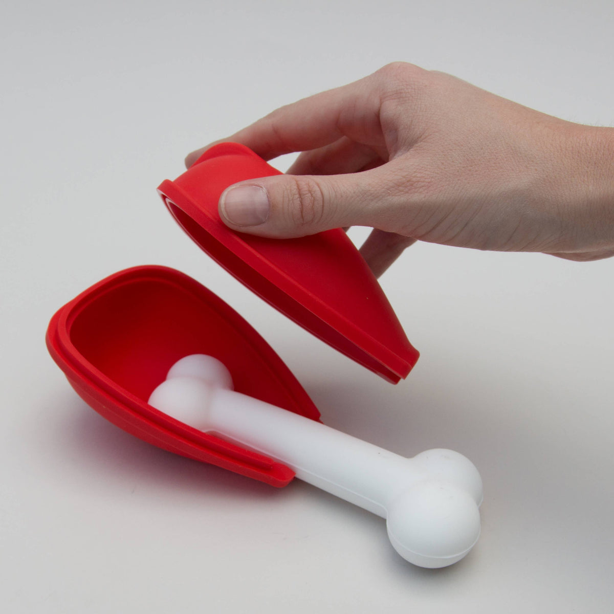Red dog ice lolly mold opened to show its white bone-shaped insert