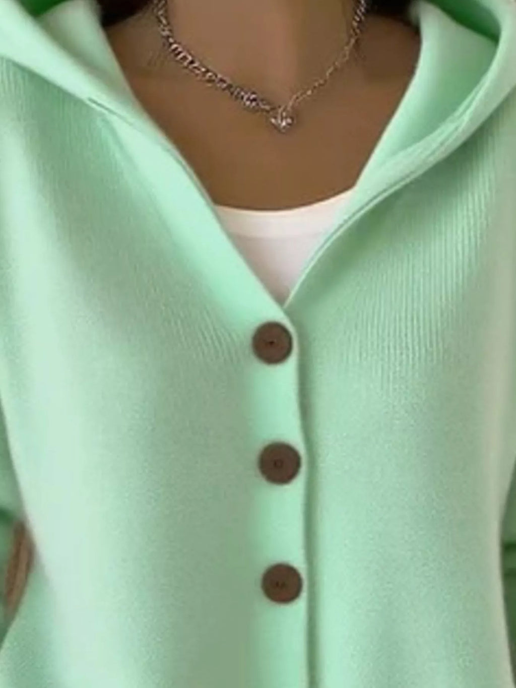 Mint green hooded knit cardigan close-up of brown buttons and V-neck opening