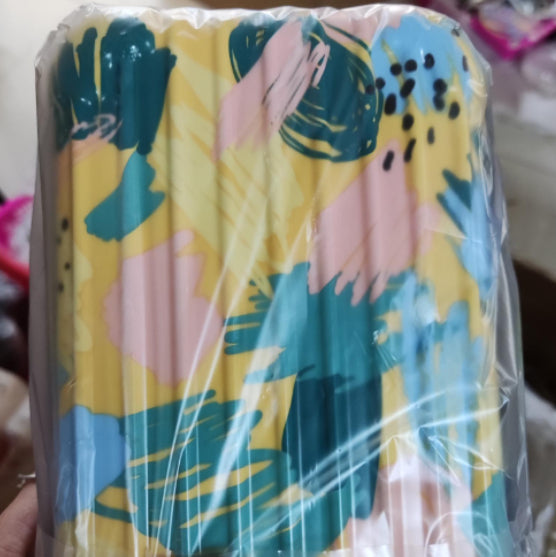 Cosmetic bag with multicolor abstract leaf pattern, sealed in plastic.