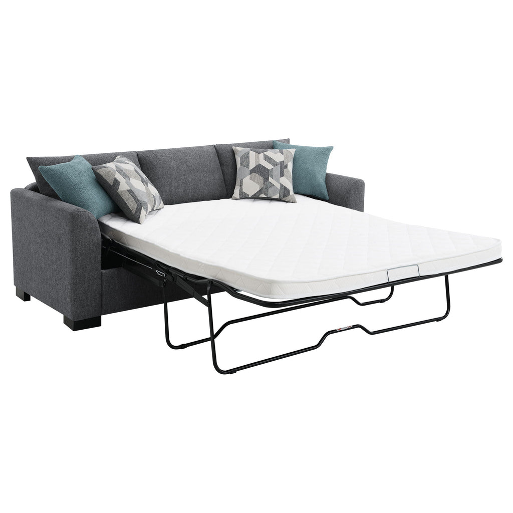 Grey upholstered sleeper sectional chaise sofa with extended white mattress and black frame