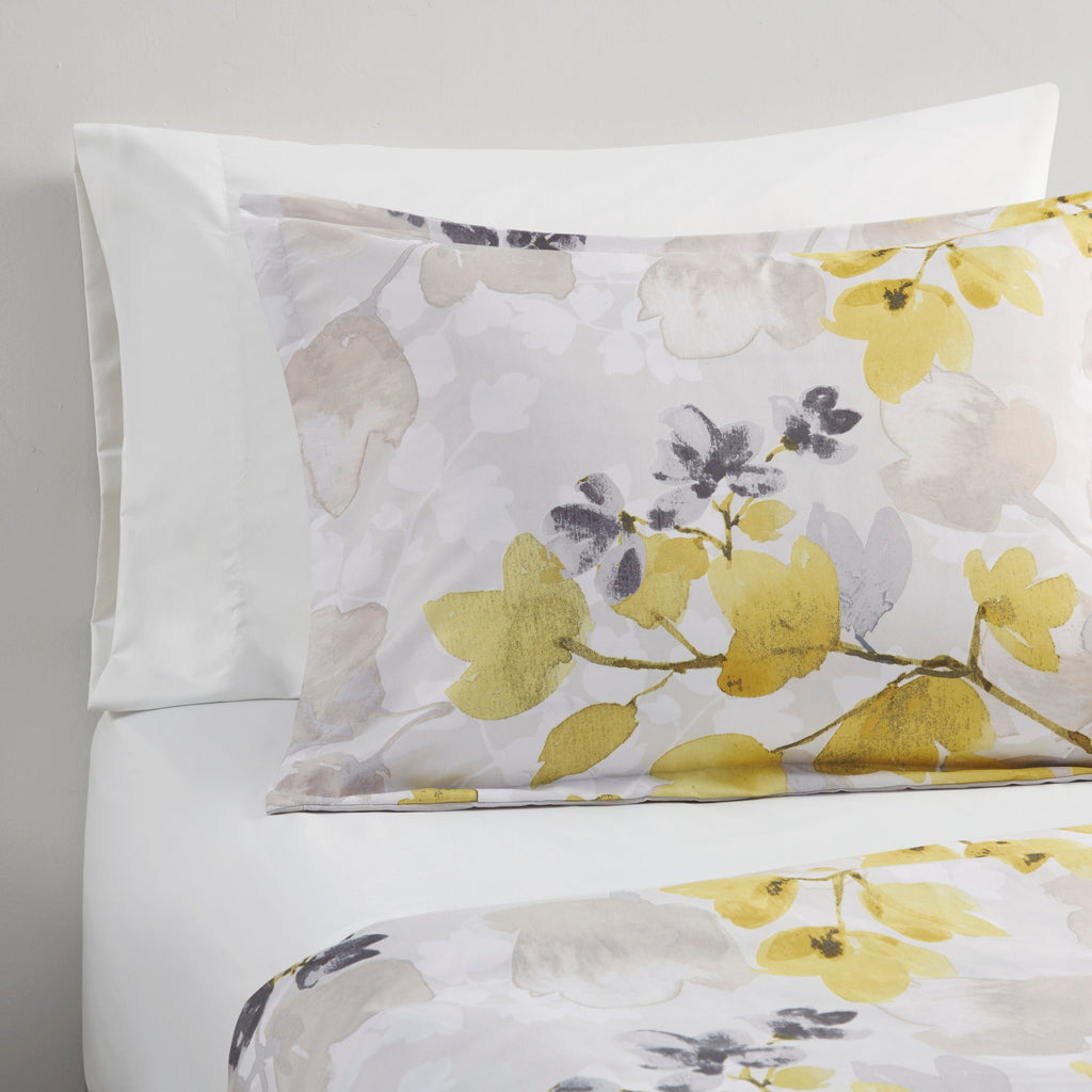 Twin XL pillow shams and white bedding with multicolor yellow floral comforter detail