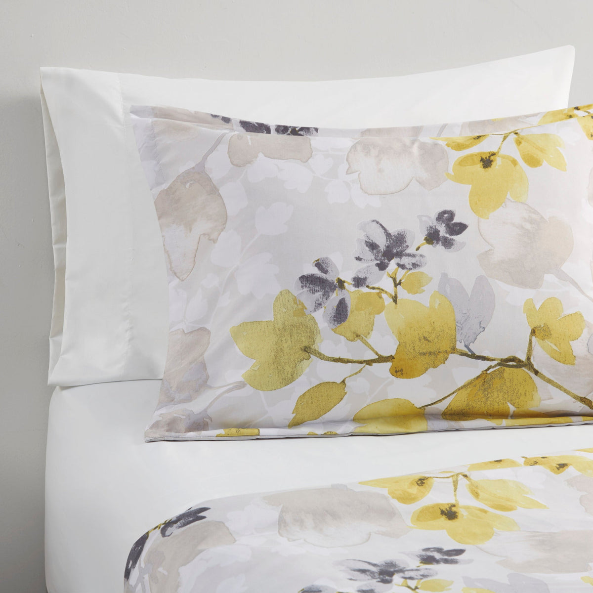 Twin XL pillow shams and white bedding with multicolor yellow floral comforter detail