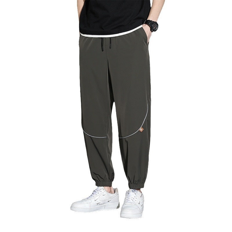 Men's tapered casual pants in dark green with drawstring waist and cuffed ankle hems