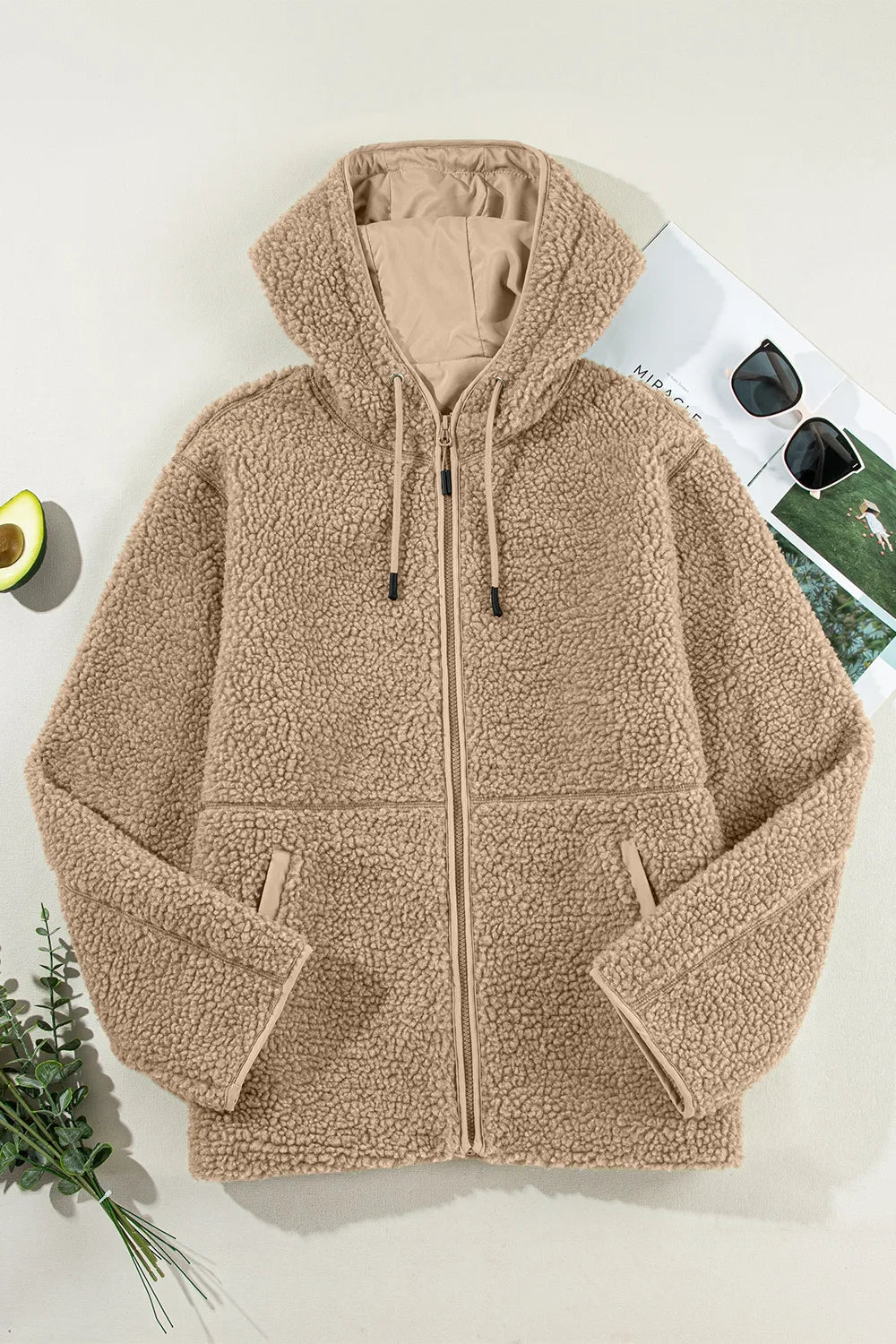 Khaki fleece zip-up hooded jacket laid flat with drawstring hood and front pockets