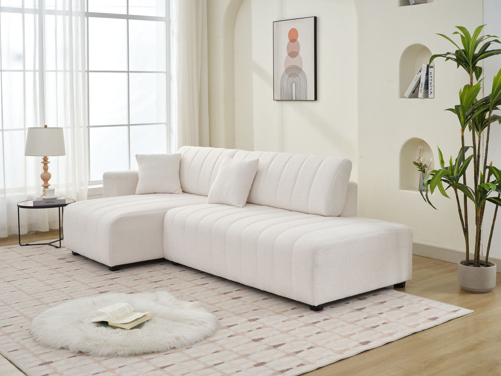 Beige lamb-wool sectional sofa with chaise in left-arm facing layout; chaise seat.