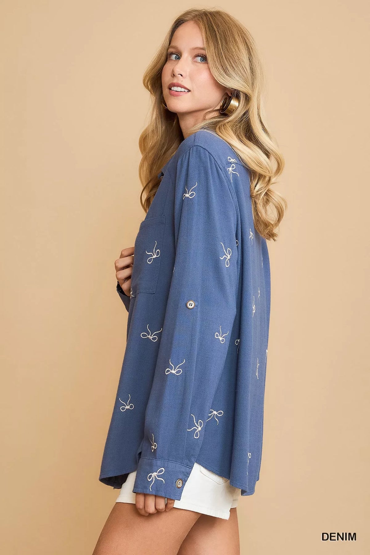 Denim blue fitted button-up shirt with ribbon bow embroidery, side view, long sleeves
