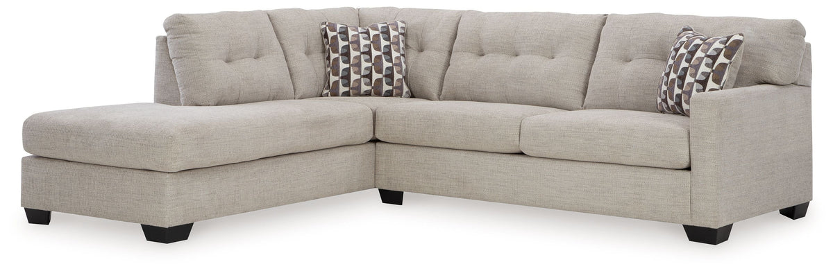 Light gray sectional sofa with corner chaise and tufted back cushions