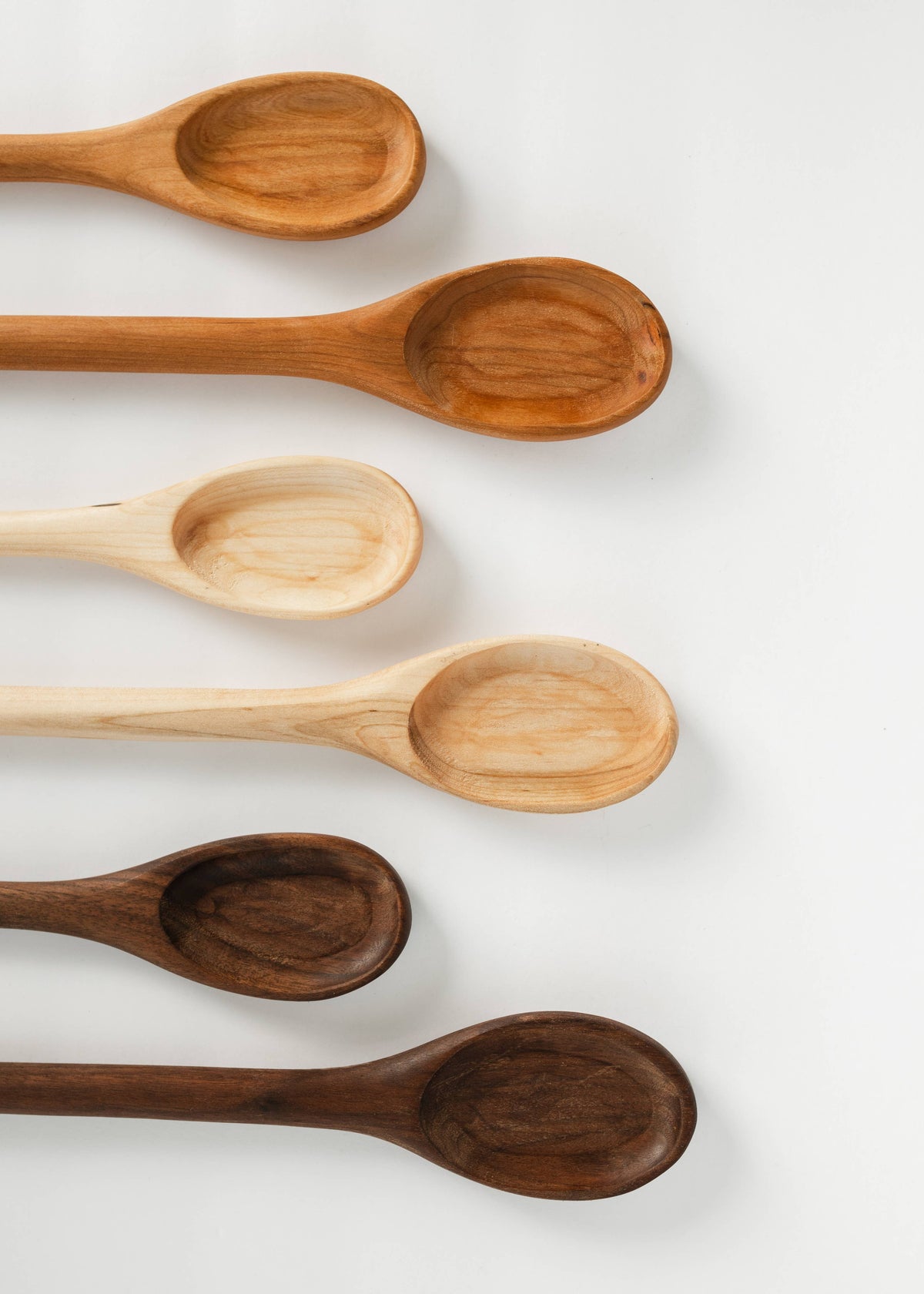 Set of wooden spoons with oval bowls and long handles, natural wood grain.